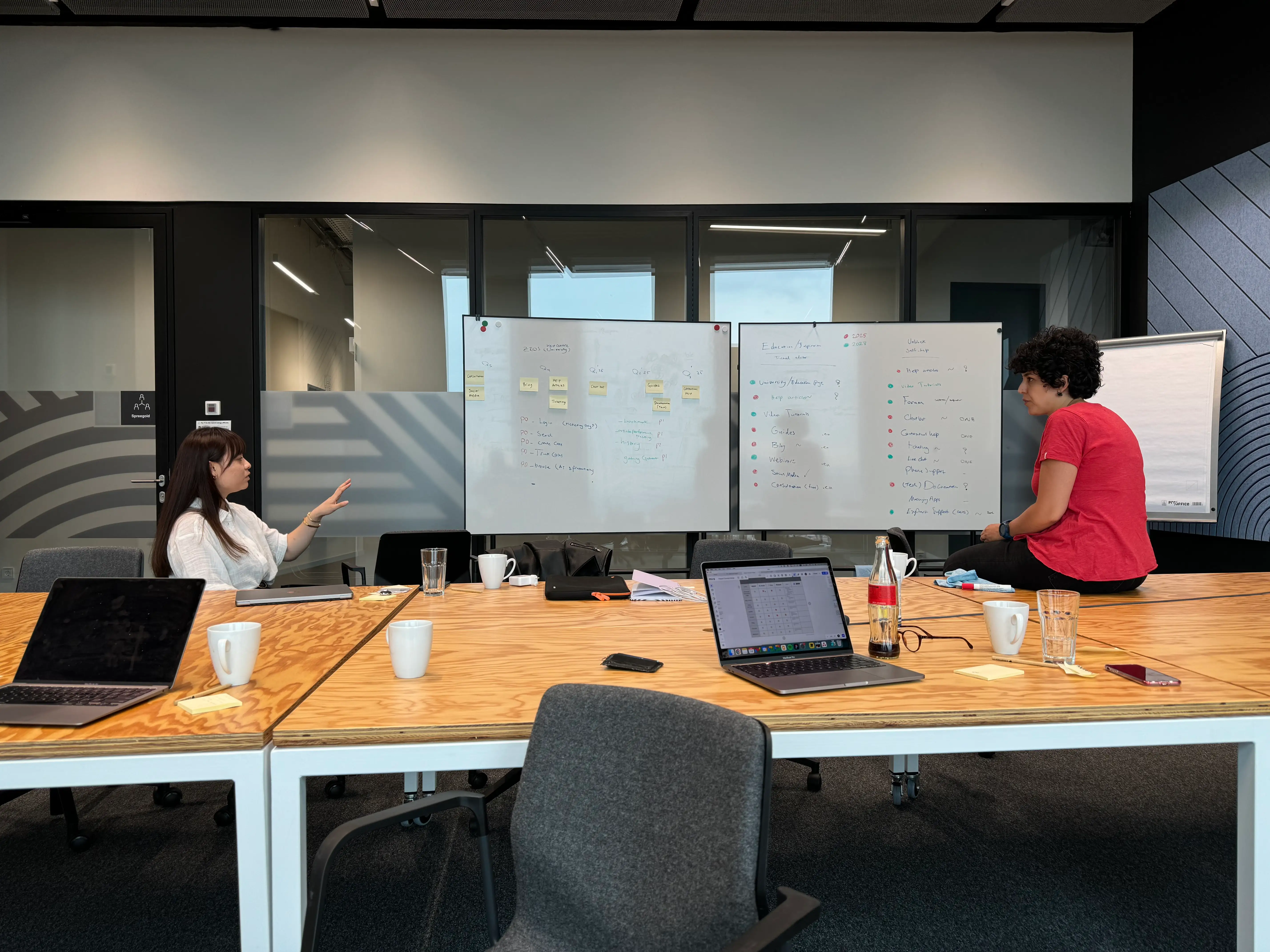 Two people sitting in fron of a whiteboard full of notes